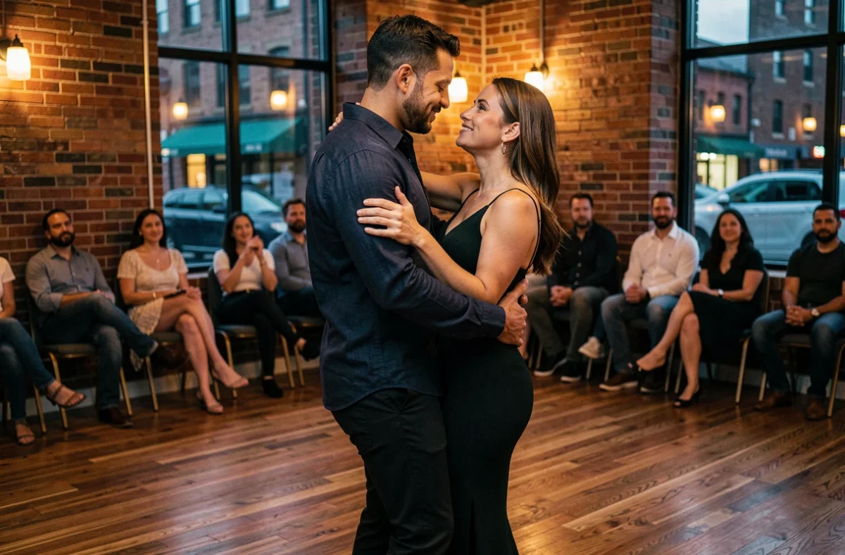 Homme guidant sa partenaire en zouk dans un studio de danse chaleureux avec murs en briques apparentes